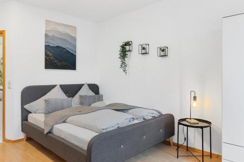 a bed in a room with a white wall at WINETIME - für 3 - nähe Madenburg - Burg Landeck in Eschbach