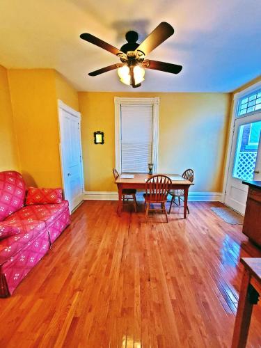 a living room with a couch and a ceiling fan at Point Breeze Guest House in Pittsburgh