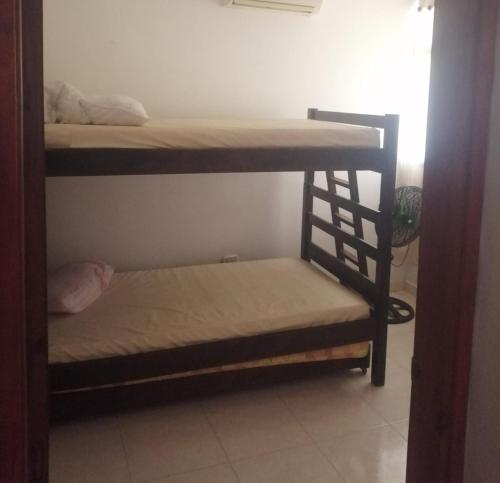 a room with two bunk beds and a chair at apto centro santa marta in Santa Marta