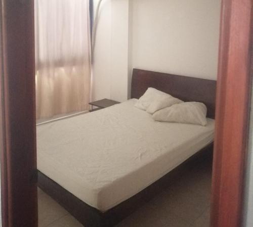 a small bedroom with a bed with a mirror at apto centro santa marta in Santa Marta