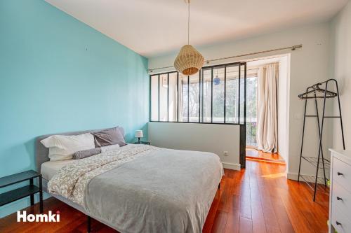 a bedroom with a bed and a large window at Beau T3-résidence calme-proche Paris/La Défense in Suresnes