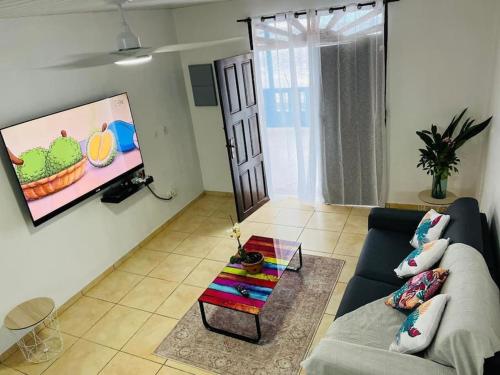 TV at/o entertainment center sa Blue Home2 T3 meublé à Matoury pour 1 à 6 voyageurs.