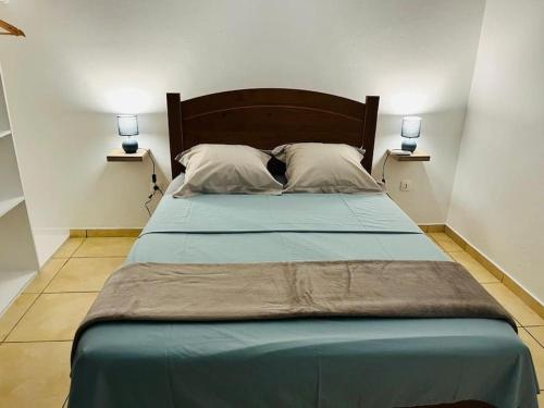 - un grand lit dans une chambre avec deux lampes latérales dans l'établissement Blue Home2 T3 meublé à Matoury pour 1 à 6 voyageurs., à Matoury