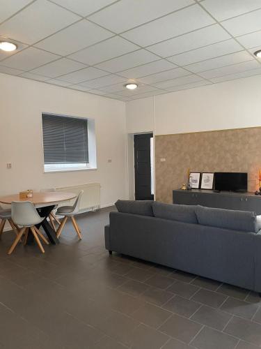 a living room with couches and a table and a tv at Stadsappartement Valkhof in Nijmegen