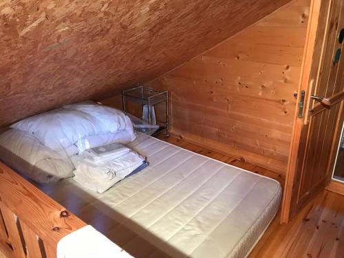 une chambre avec un lit dans une pièce en bois dans l'établissement La casa noya sur la route du débarquement d omaha beach, à Le Grand-Hameau