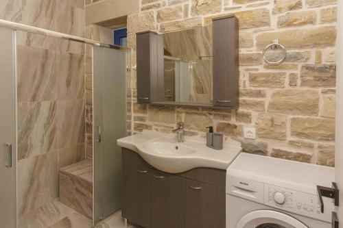 a bathroom with a sink and a washing machine at Bellus Residence! in Ambeloúzos
