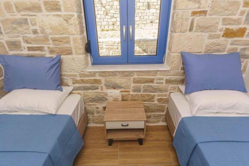 two beds in a room with two windows at Bellus Residence! in Ambeloúzos
