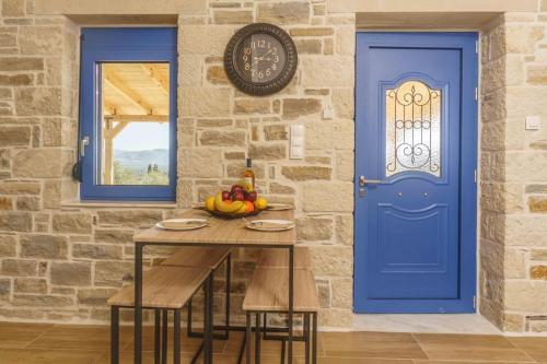 a blue door and a table with a bowl of fruit at Bellus Residence! in Ambeloúzos