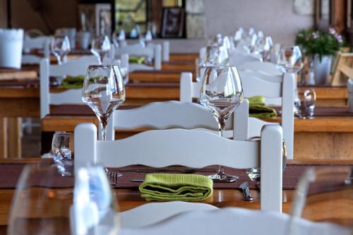 a table with white chairs and wine glasses on it at Auberge de la Tour de Brison in Sanilhac