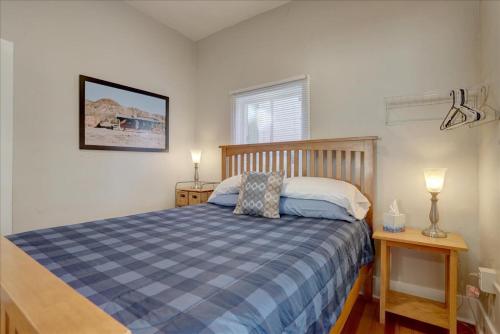 een slaapkamer met een blauw en wit bed en 2 tafels bij Retro bungalow workspace fast WiFi in Louisville