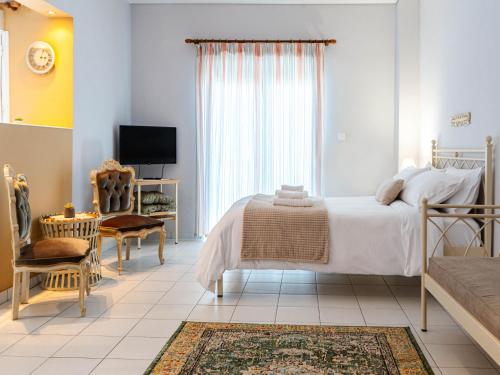 a white bedroom with a bed and a tv at 4keys House 4 in Tripolis