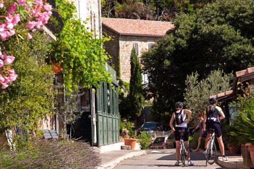 two people are riding bikes down a street at Auberge de la Tour de Brison in Sanilhac