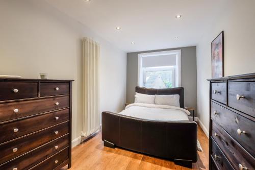 a bedroom with a bed and a dresser at Sleek 2B/1B Retreat in Lindley, Huddersfield in Lindley
