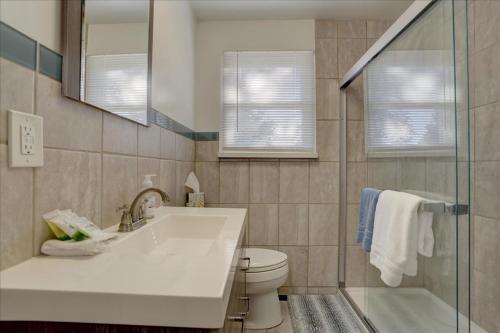 een badkamer met een wastafel, een toilet en een spiegel bij Retro bungalow workspace fast WiFi in Louisville