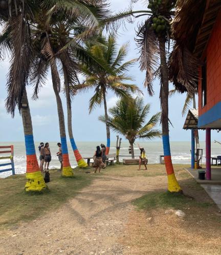 a group of people walking on a beach with palm trees at Hotel EL PALMAR TOURS in Arboletes