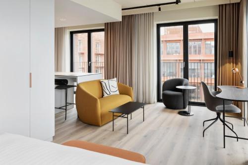 コペンハーゲンにあるResidence Inn by Marriott Copenhagen Nordhavnの黄色い椅子とデスクが備わる客室です。