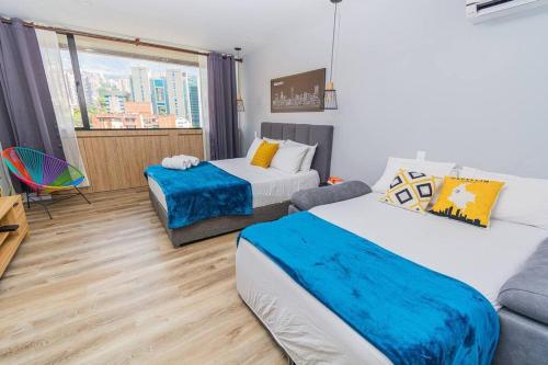 un salon avec deux lits et un canapé dans l'établissement Poblado, Modern studio, coworking, A/C, Gym 1411, à Medellín