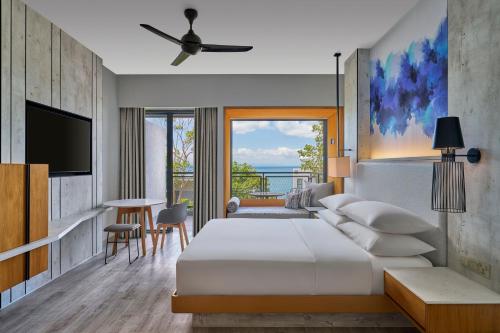 Perhentian Marriott Resort & Spa في بيرهينتيان: غرفه فندقيه سرير وتلفزيون