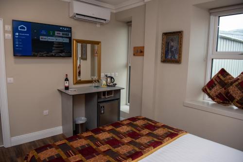 a bedroom with a bed and a sink and a mirror at Donegal House in Donegal