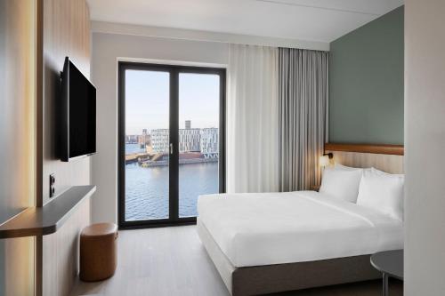 a hotel room with a bed and a large window at Fairfield by Marriott Copenhagen Nordhavn in Copenhagen