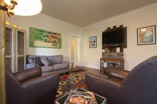 a living room with couches and a flat screen tv at Retro Bungalow in Santa Rosa