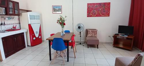 a kitchen with a table with blue chairs and a refrigerator at Apartamentos Nokal in Masaya