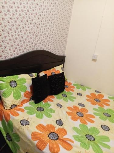 a bed with orange and green flowers on it at Khalidiya in Abu Dhabi