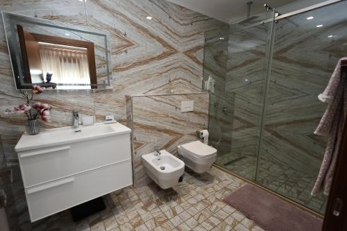 uma casa de banho com um chuveiro, um WC e um lavatório. em Rezidenca Arlington em Berat