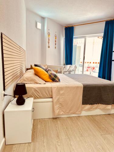 a bedroom with a large bed with blue curtains at Studio Apartment Santana Habaneras - 18 at Beach with Garage, Pool and Lift in Torrevieja
