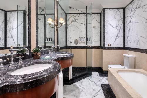a bathroom with two sinks and a shower and a tub at Hotel Grande Bretagne, a Luxury Collection Hotel, Athens in Athens