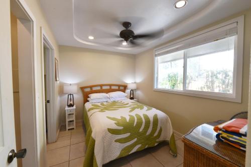 a bedroom with a bed and a window at Waimanalo Beach Cottages in Waimanalo