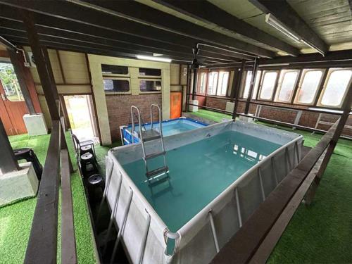 a large pool in the middle of a house at Resort D Rumah Bonda River View Kuala Kangsar in Kampong Senawar