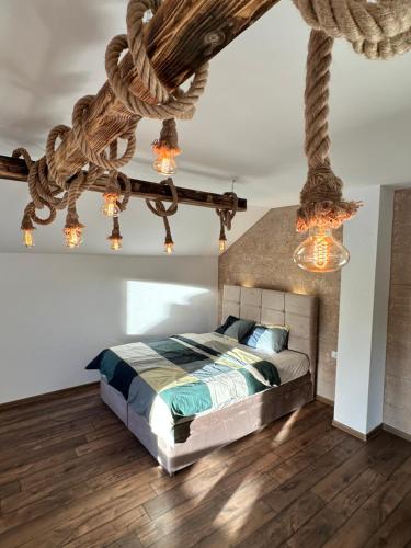 1 dormitorio con cama y lámpara de araña en Rustic Luxury Villa Drina Drlače, en Ljubovija
