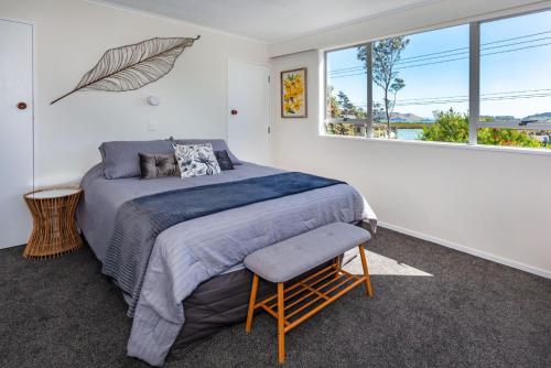 a bedroom with a bed and a large window at Heart of town in Coromandel Town