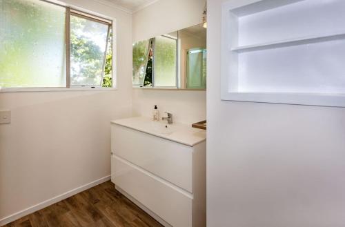 a bathroom with a sink and a mirror at Heart of town in Coromandel Town
