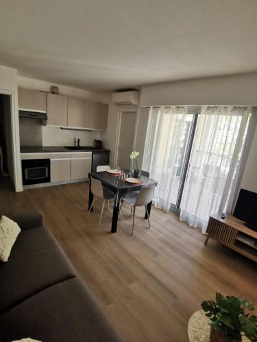 un salon avec un canapé et une table et une cuisine dans l'établissement Lido, private apartment seaside, parking, swimming pool, à Cagnes-sur-Mer
