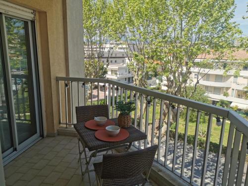 a balcony with a table and chairs on a balcony at Lido, private apartment seaside, parking, swimming pool in Cagnes-sur-Mer
