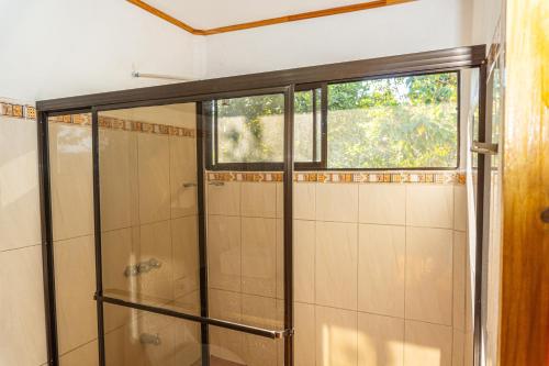 ein Bad mit einer Dusche und einem Fenster in der Unterkunft Villa Manolo Ocean and Forest View Hotel in Drake