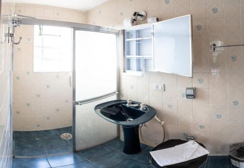 a bathroom with a sink and a shower at Chalés Vill'Agi in Campos do Jordão