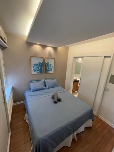 a bedroom with a large bed with blue pillows at Flat novo e equipado - Brasília/Sudoeste in Brasília