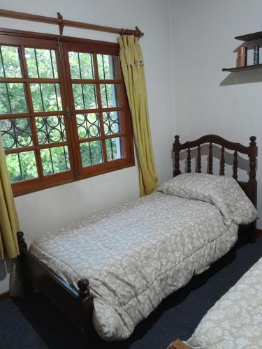 Un dormitorio con una cama y una ventana grande en Un ambiente cómodo y placentero, en Guaymallén