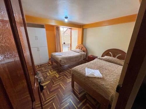 a hotel room with two beds and a window at killa Anqas House in Cusco