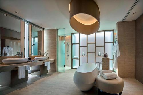 baño con bañera grande y espejo grande en The Ritz-Carlton, Koh Samui en Choeng Mon Beach