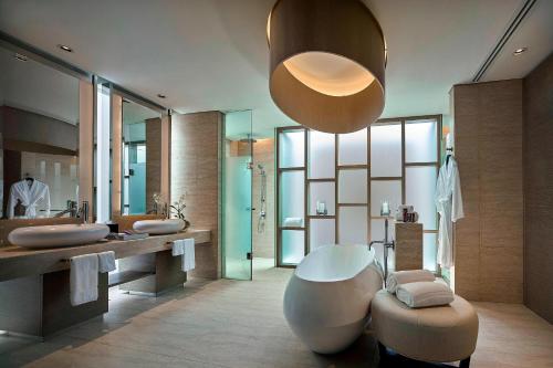 a bathroom with a large tub and a large mirror at The Ritz-Carlton, Koh Samui in Choeng Mon Beach