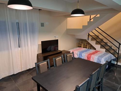 a living room with a dining room table and a staircase at SUN WINE in Guaymallen