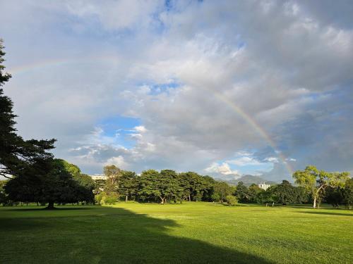a rainbow in the sky over a field with trees at Burundi Palace Boutique Hotel in Bujumbura