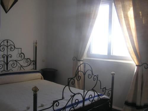 a bedroom with a bed and a window at Dar Al Bahar in Essaouira