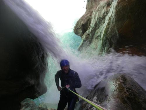 a man is standing in front of a waterfall at Alojamiento Rural El Brazal in Lanjarón