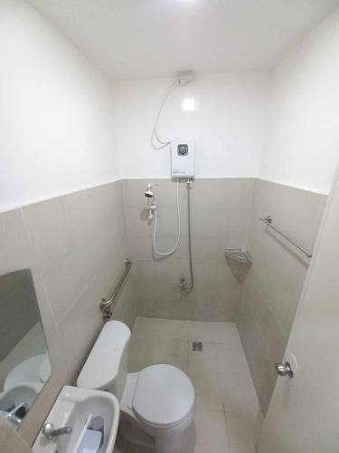 a bathroom with a toilet and a shower and a sink at ConVill Residences in General Santos