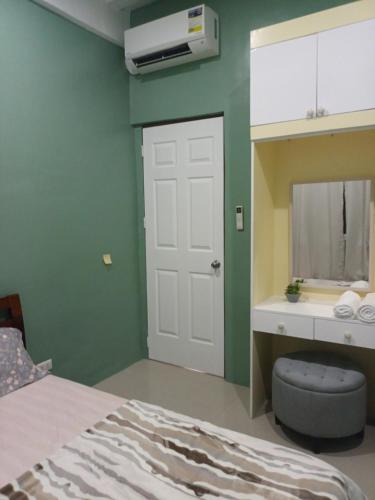 a bedroom with a white door and a green wall at ConVill Residences in General Santos